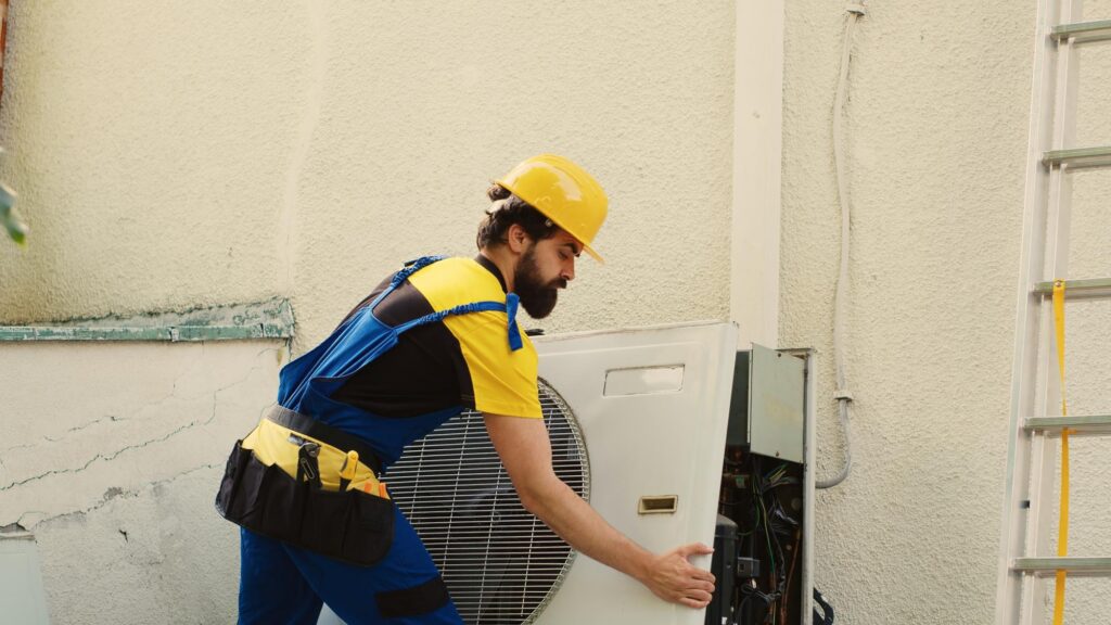 HVAC technician repairing an outdoor AC condenser unit in North Georgia.